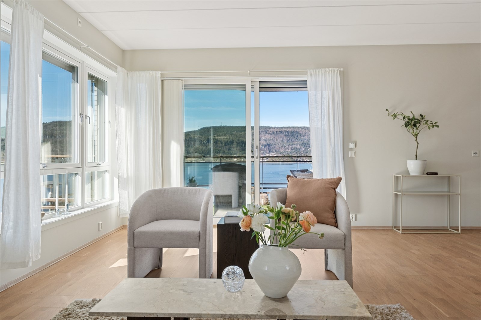 Rommet har store vinduer og balkongdør i glass med utgang til balkong som slipper inn godt med dagslys og sikrer den spektakulære sjøutsikten. Galleribilde