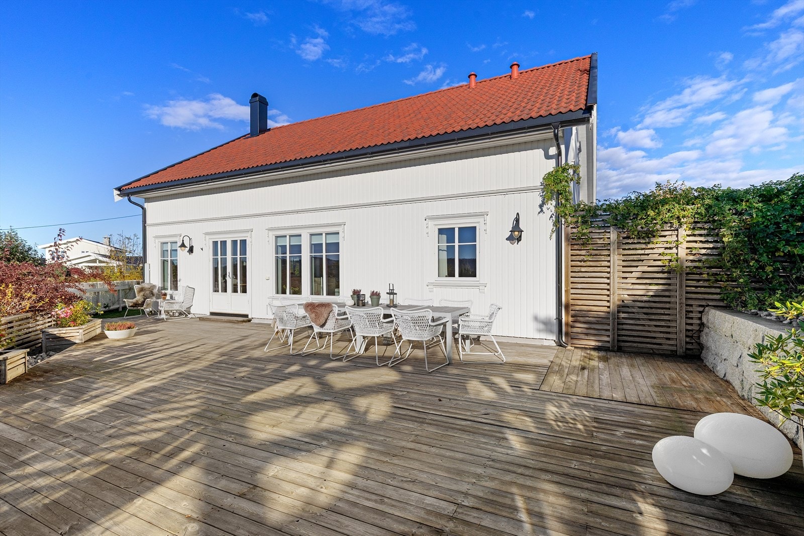 Hele uteområdet ble opparbeidet med ny terrasse, pergola, blomsterkasser, trapp og stakittgjerde som omkranser eiendommen på en sjarmerende måte. Galleribilde