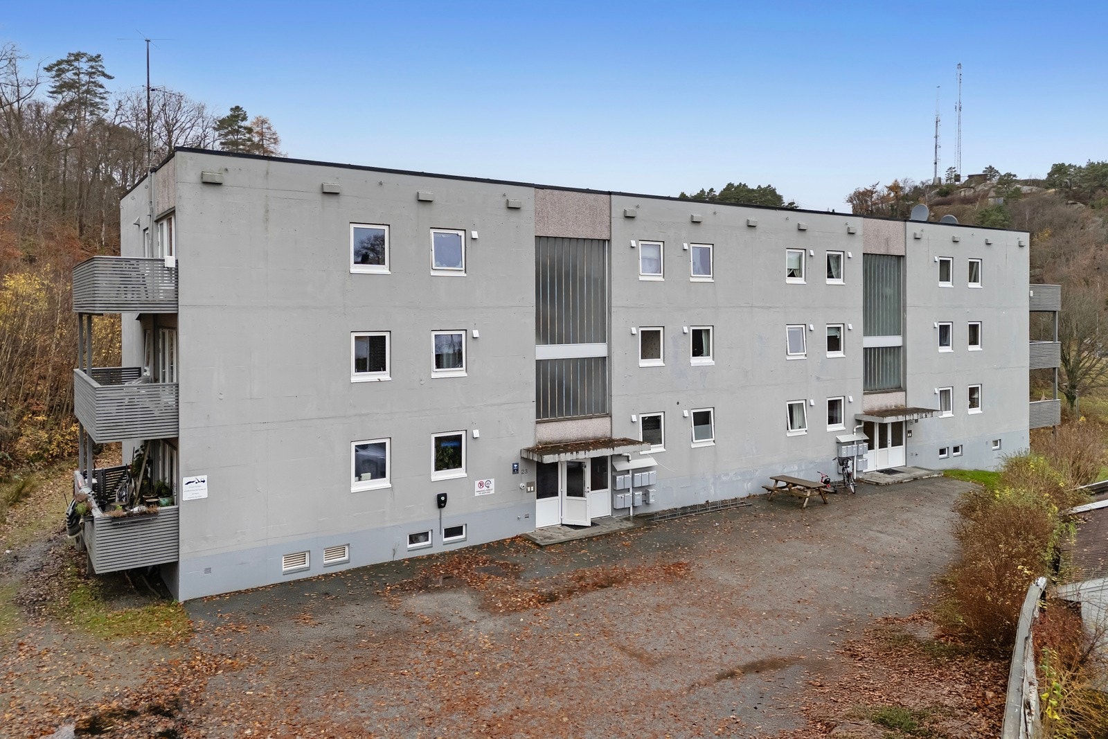 Boligblokken har et stort asfaltert parkeringsområde uten faste parkeringsplasser. Galleribilde