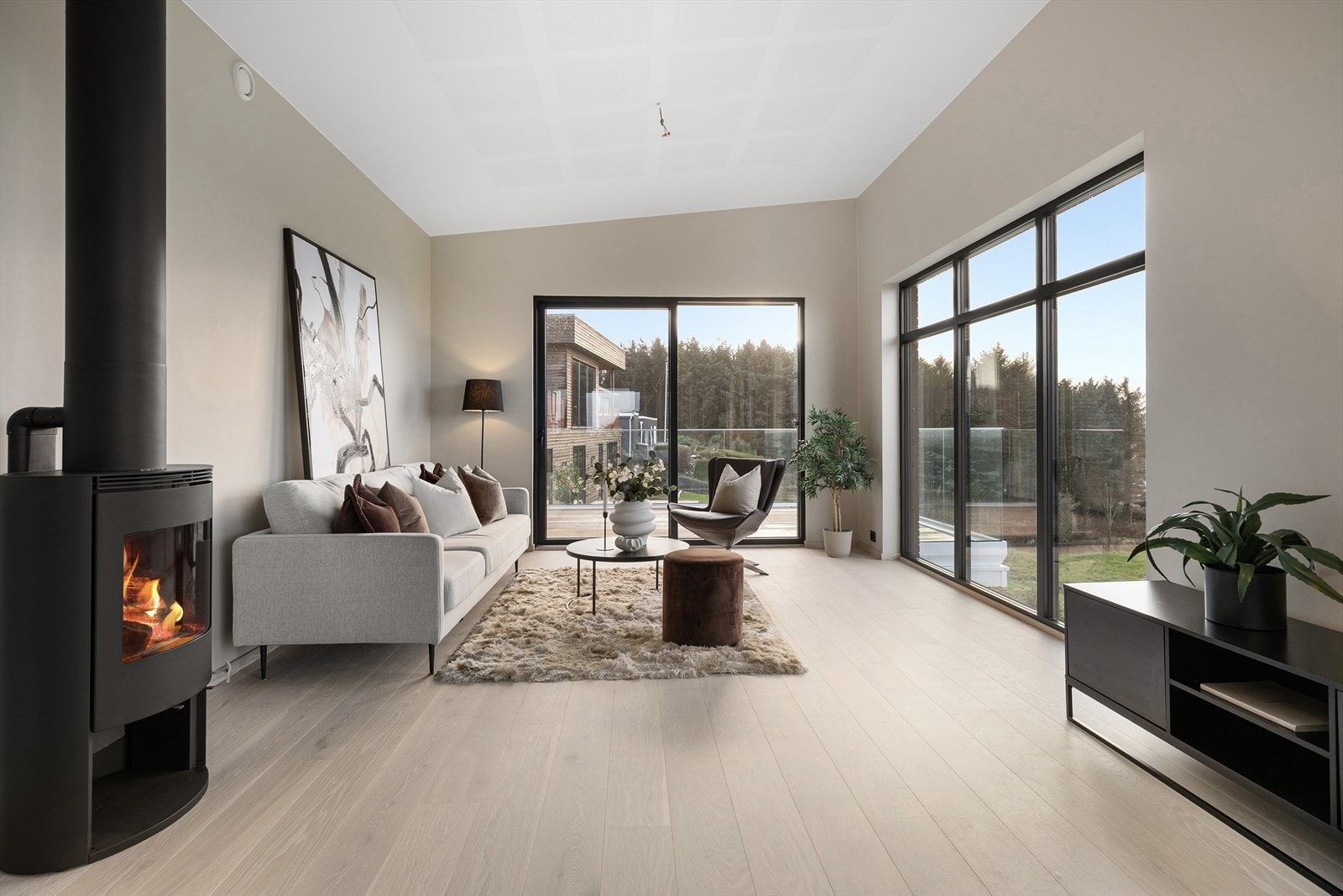 Velkommen inn! Stuen byr på generøs takhøyde og store vindusflater. Galleribilde