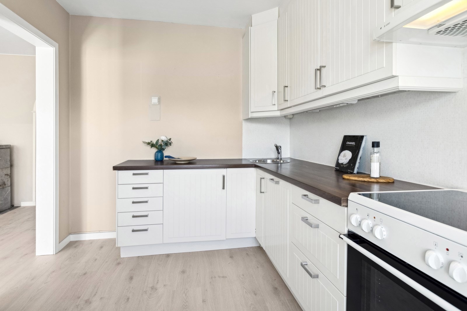 Kjøkkeninnredning består av folierte skrog med profilerte fronter og laminert benkeplate. Integrert oppvaskmaskin og ventilator. Galleribilde