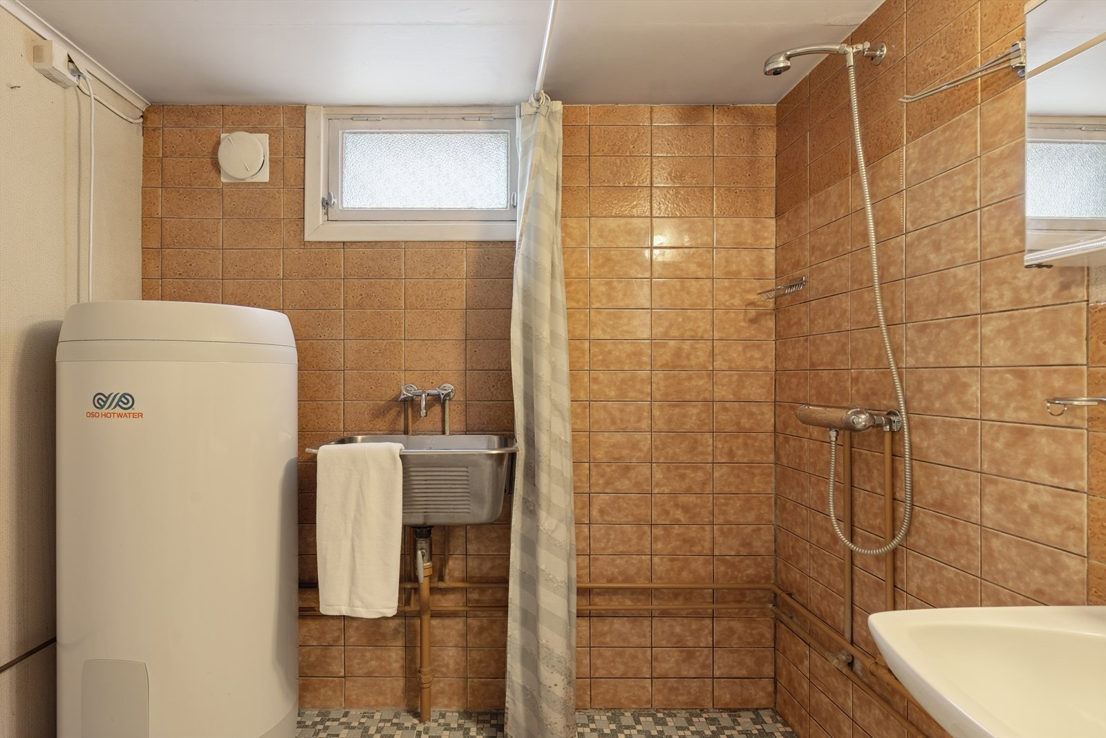 Innredningen består av servant, toalett, dusjhjørne med dusjvegger, og det er opplegg for vaskemaskin. Galleribilde