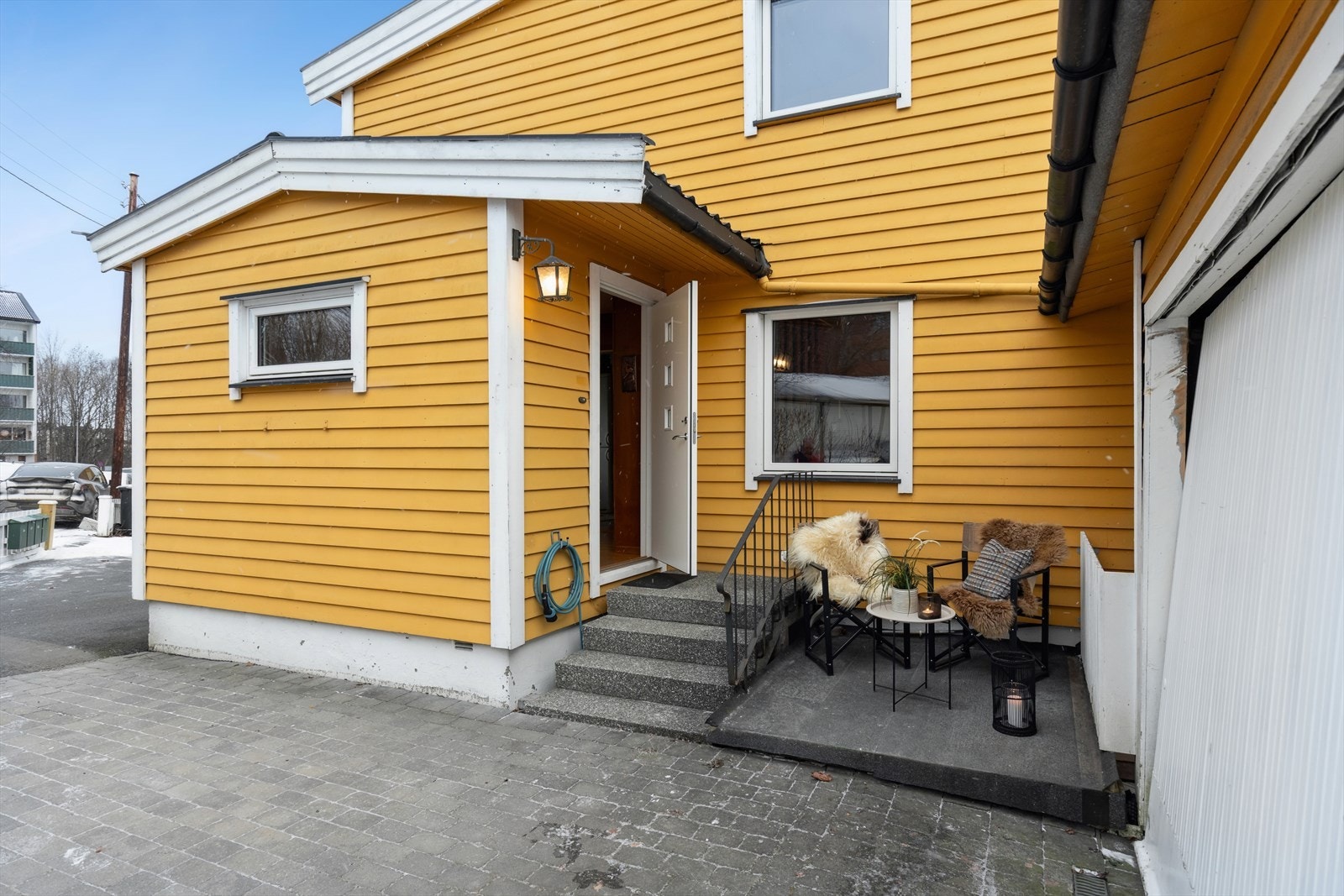 Inngangspartiet har en steinbelagt hyggelig uteplass. Det er opplegg for elbillader. Galleribilde