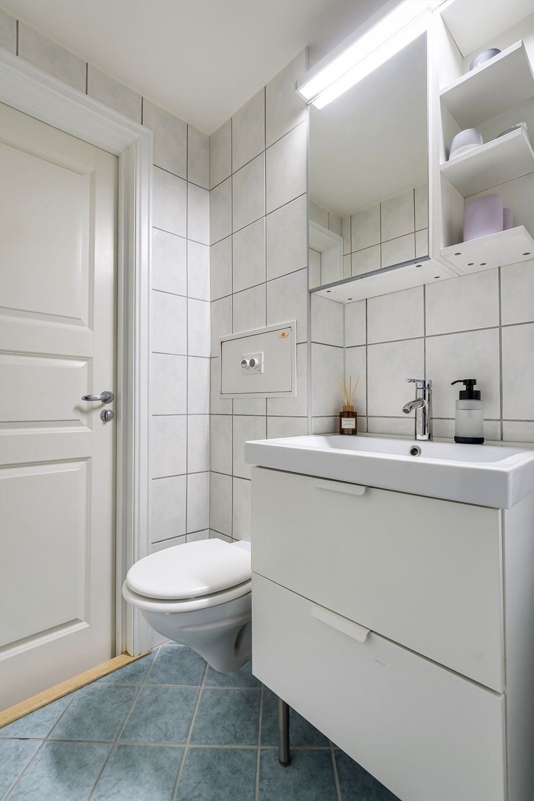 Badet inneholder vegghengt wc, servant, dusjhjørne og opplegg for vaskemaskin. Galleribilde