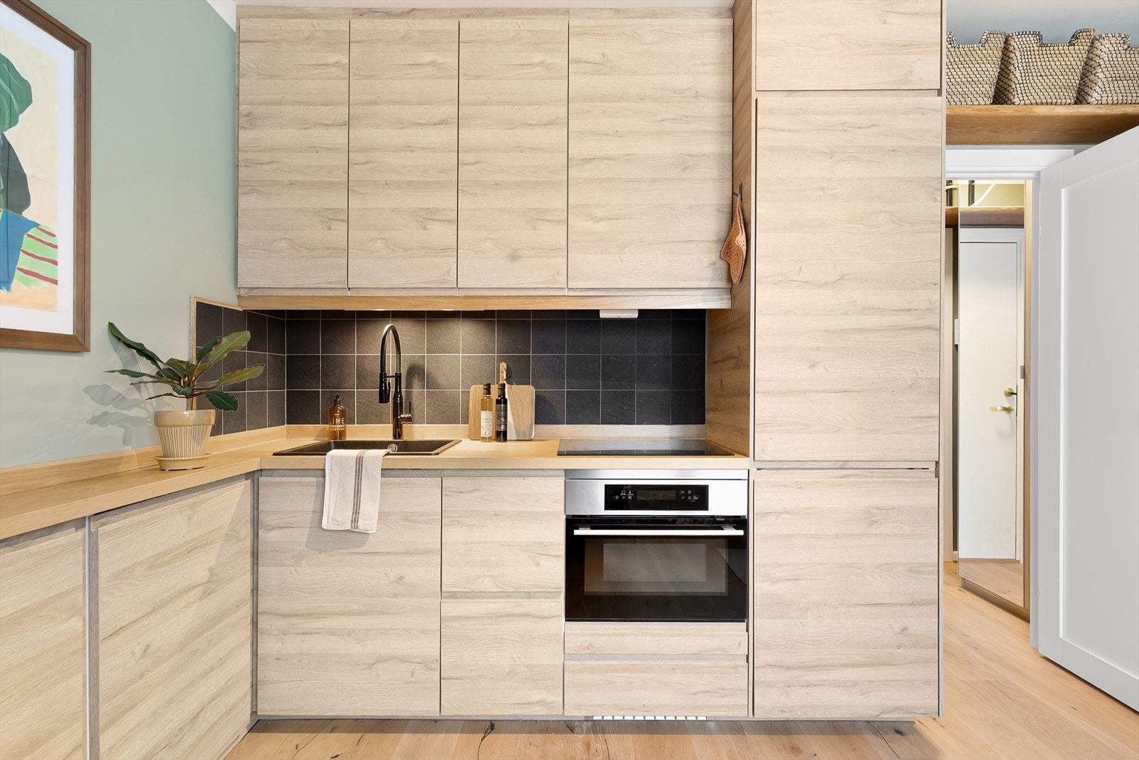 Kjøkkenet har induksjonsplatetopp og komfyr med innebygget mikrobølgeovn. Galleribilde