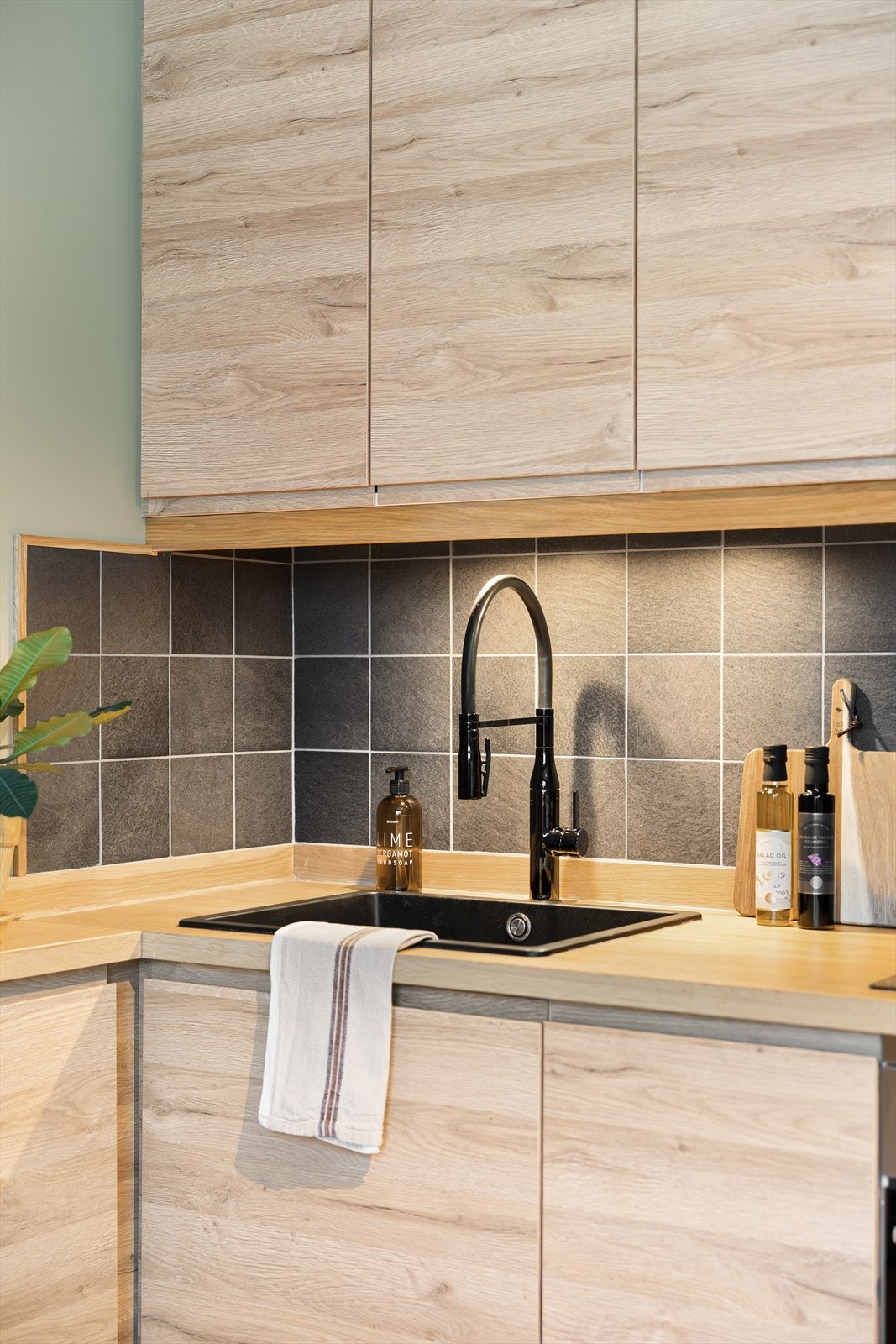 Kjøkkenet består av fliser mellom overskap og benkeplate i tre, kullfiltervifte over integrert koketopp/ovn, lys/lyslist under overskap og integrert kjøl/frys. Galleribilde