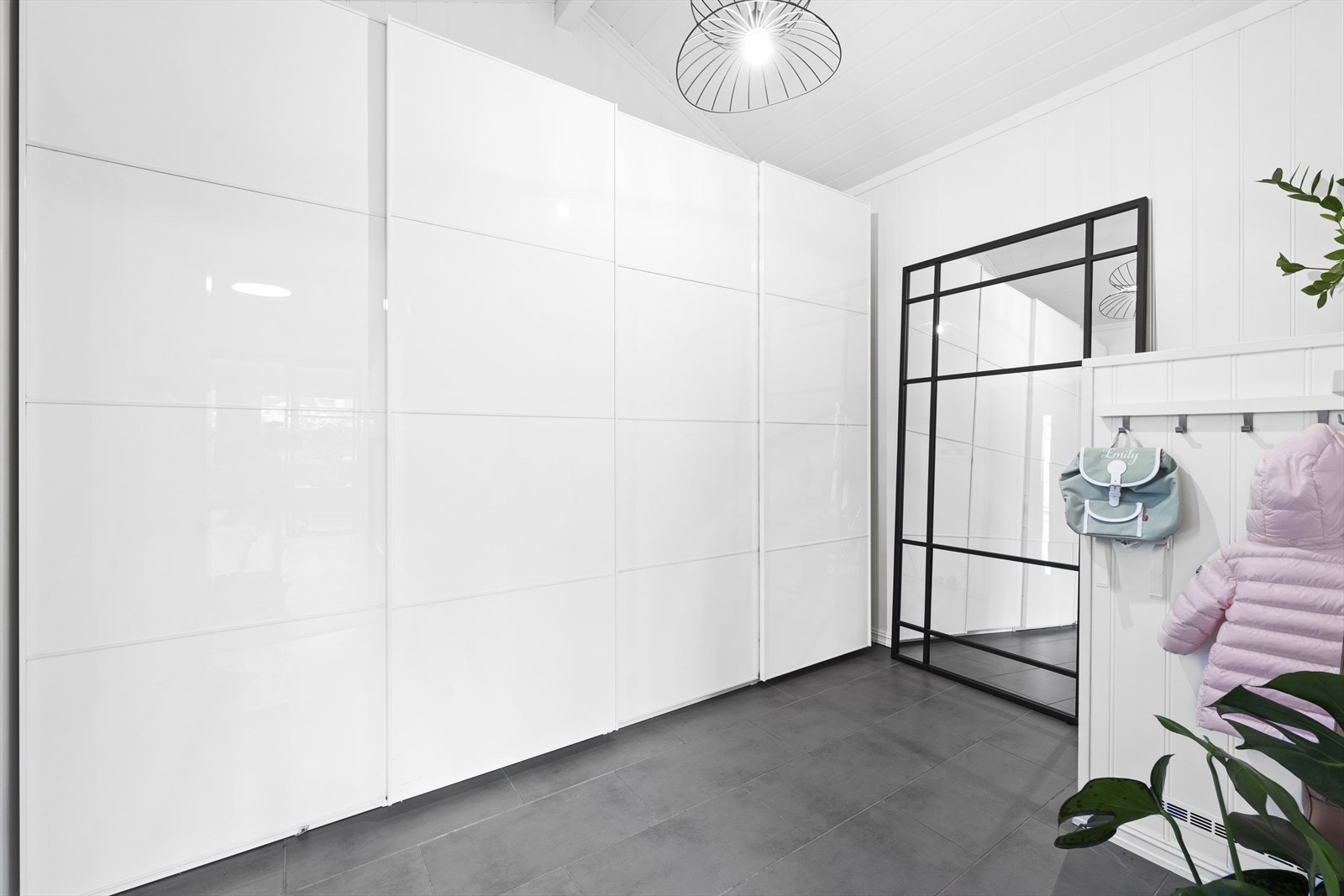 Du ønskes velkommen inn i en stor, lys og innbydende entré med flislagt gulv og en svært romslig skyvedørsgarderobe som gir rikelig med plass til hele familiens yttertøy. Galleribilde