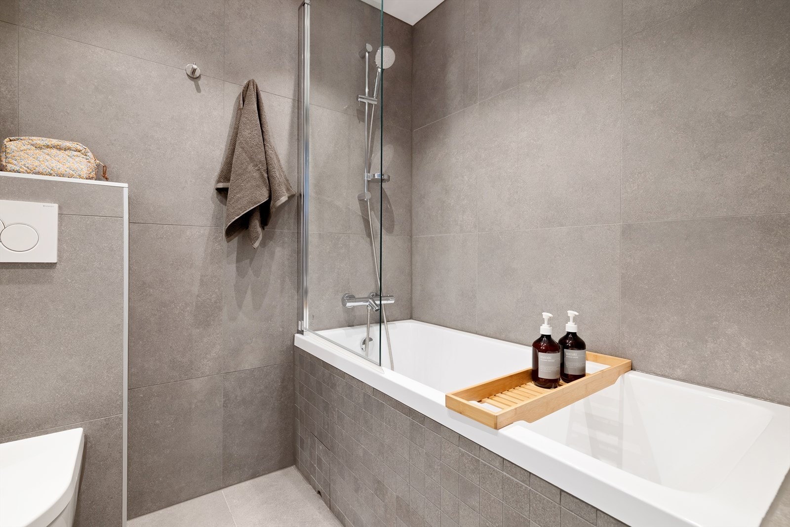 Innredningen inkluderer servant, veggmontert toalett og et deilig badekar for avslapningsstunder. Galleribilde