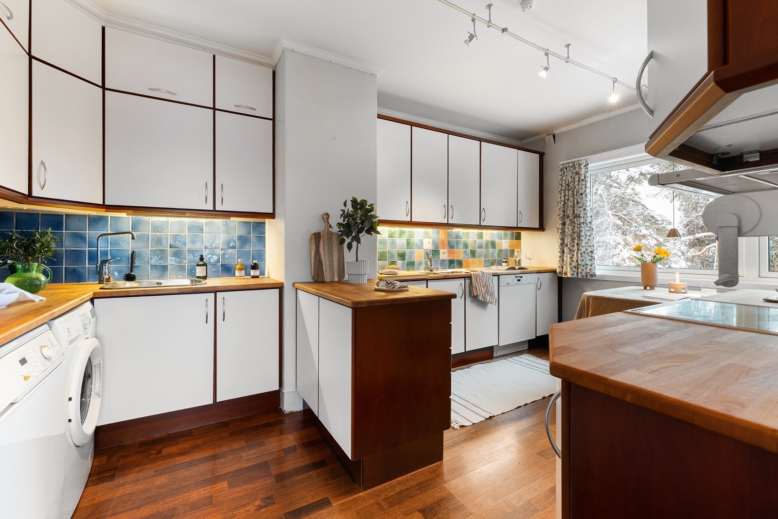 Kjøkken med glatte fronter og en benkeplate i heltre som gir rommet et varmt og naturlig preg. Galleribilde