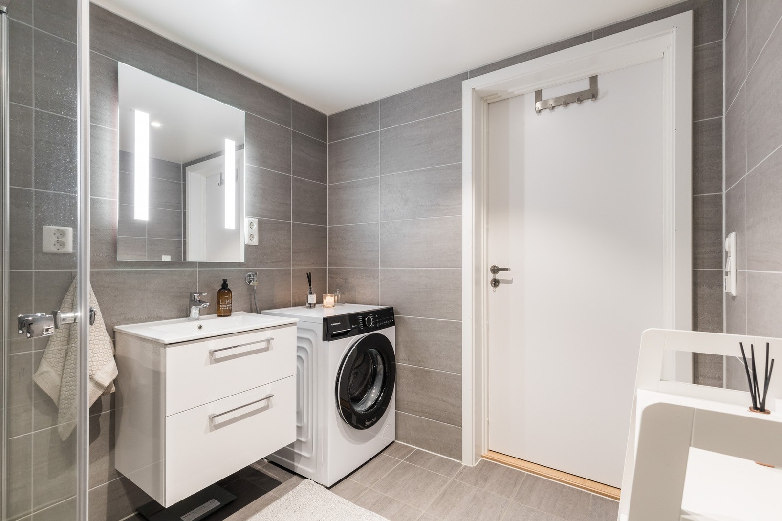 Baderommet er svært delikat med følgende inventar: servant med skuffer, speil med belysning, dusjhjørne med foldedører og opplegg for vaskemaskin og tørketrommel. Galleribilde