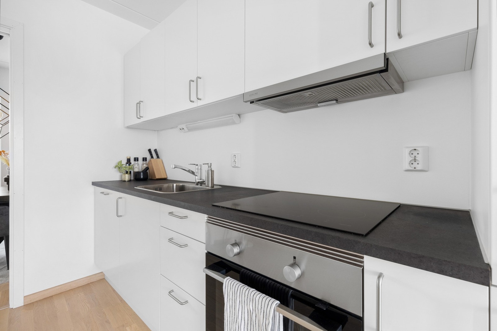 Integrerte hvitevarer som inkluderer oppvaskmaskin, ovn, koketopp og kjøl-/fryseskap. Galleribilde