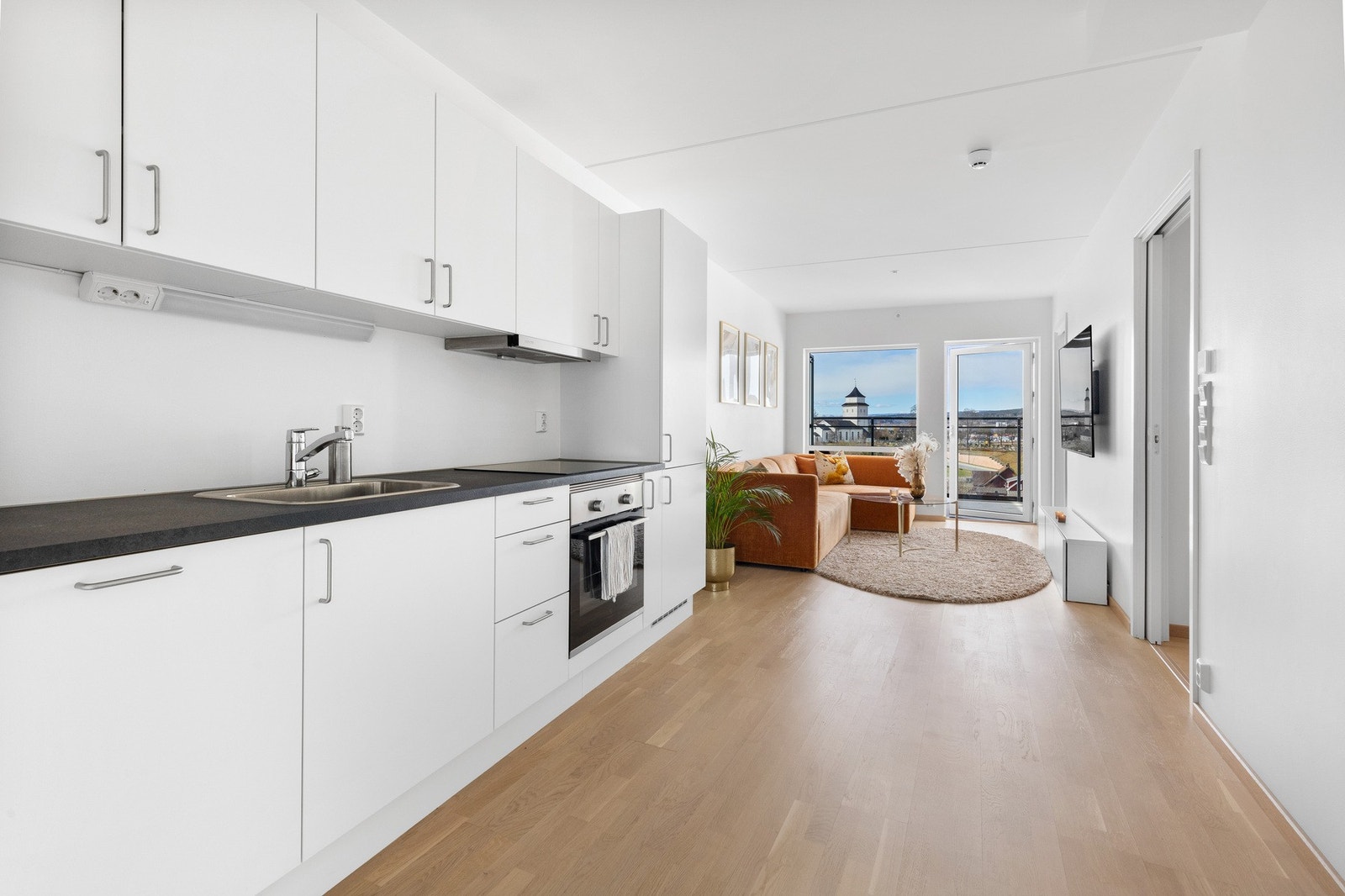 Pent kjøkken med slette fronter og integrerte hvitevarer. Galleribilde