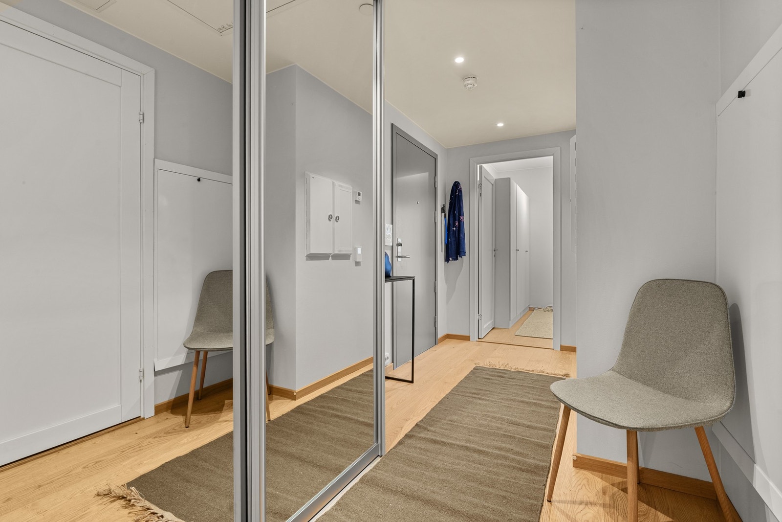 Leiligheten har en innbydende entré med moderne overflater og hvitmalte innerdører som gir adkomst til øvrige rom. Entrédøren er klassifisert for brann og lyd (B30/43 dB), noe som bidrar til økt sikkerhet og god støyisolasjon. Det er plass til en romslig Galleribilde