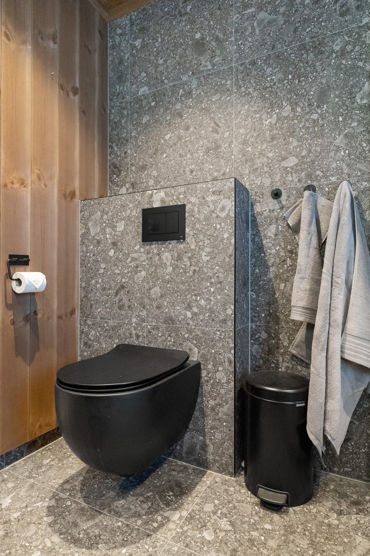 Baderommet er innredet med stilren baderomsinnredning, veggmontert toalett, frittstående badekar og dusjløsning med dusjvegger Galleribilde