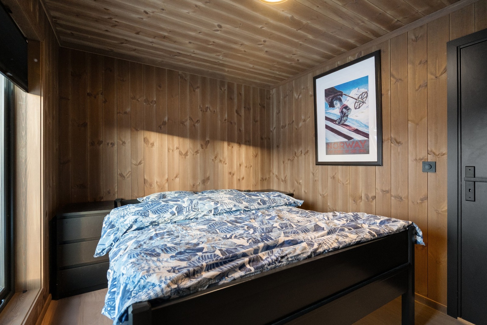 Hyttas hovedplan rommer tre innbydende soverom, alle utført i en lun og gjennomført hyttestil med heltrepanel på vegger og himling. Galleribilde