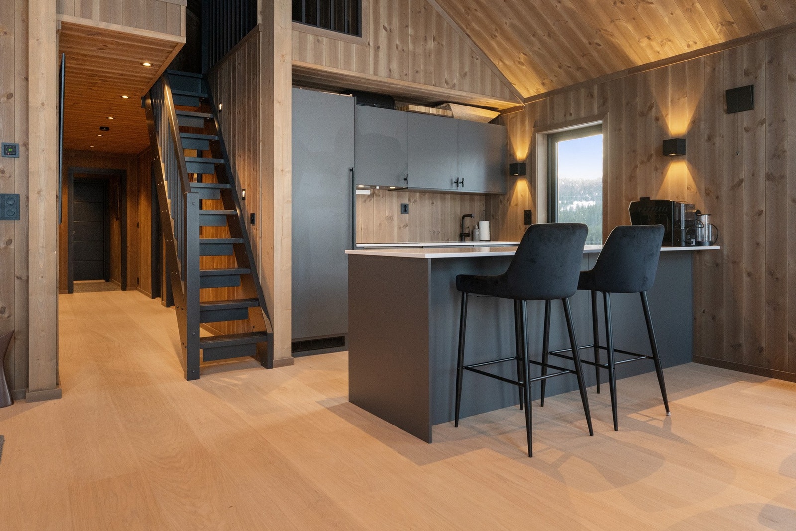 En praktisk kjøkkenøy gir rikelig med arbeidsplass og mulighet for sitteplasser ved benken. Galleribilde