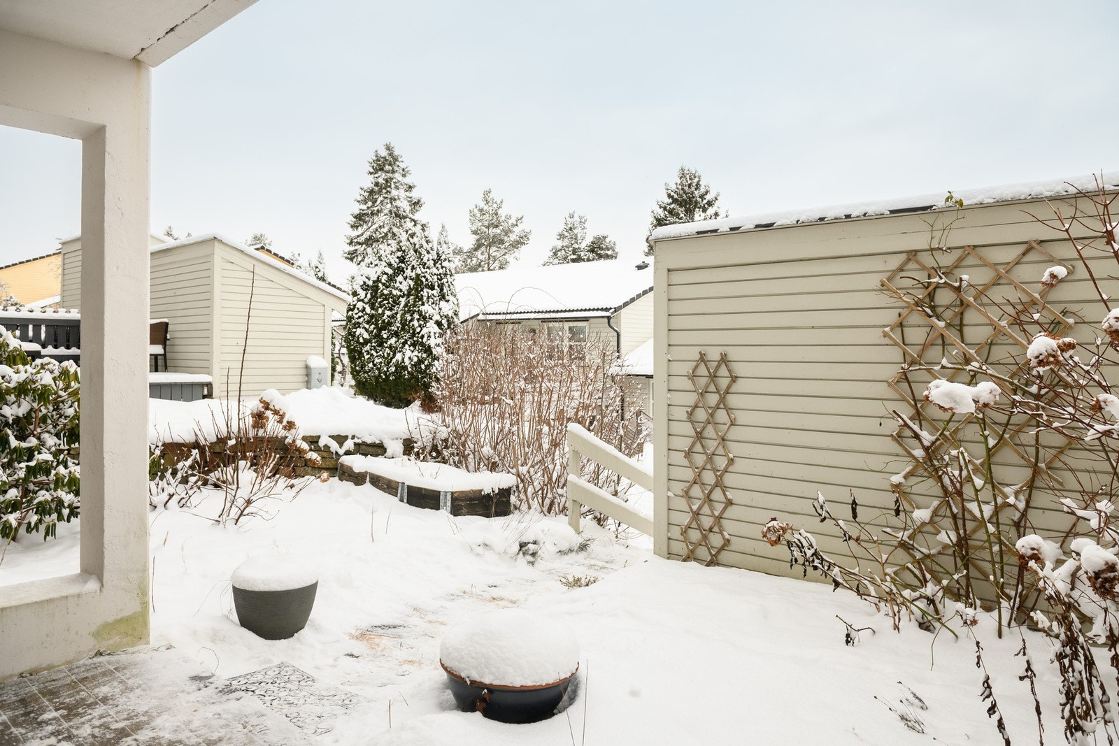 Fra veien er det trapp opp til et hellelagt uteområde med diverse beplantning. Galleribilde
