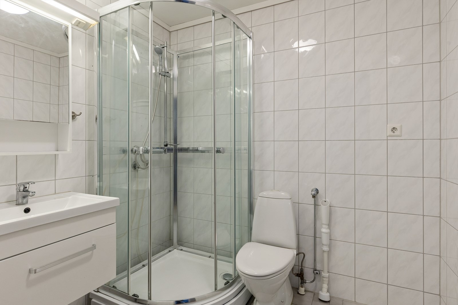 Rommet har flislagte overflater på både vegger og gulv, som gir en slitesterk og lettstelt løsning. Galleribilde