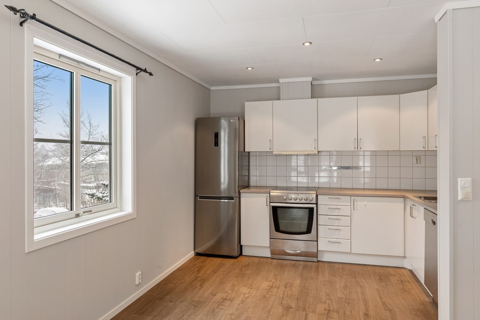 Kjøkkenet er fra byggeåret 2004 og fremstår som et praktisk og funksjonelt rom med god arbeidsplass. Innredningen består av glatte fronter i tidløst uttrykk og en laminert benkeplate som gir et rent og ryddig preg. Galleribilde