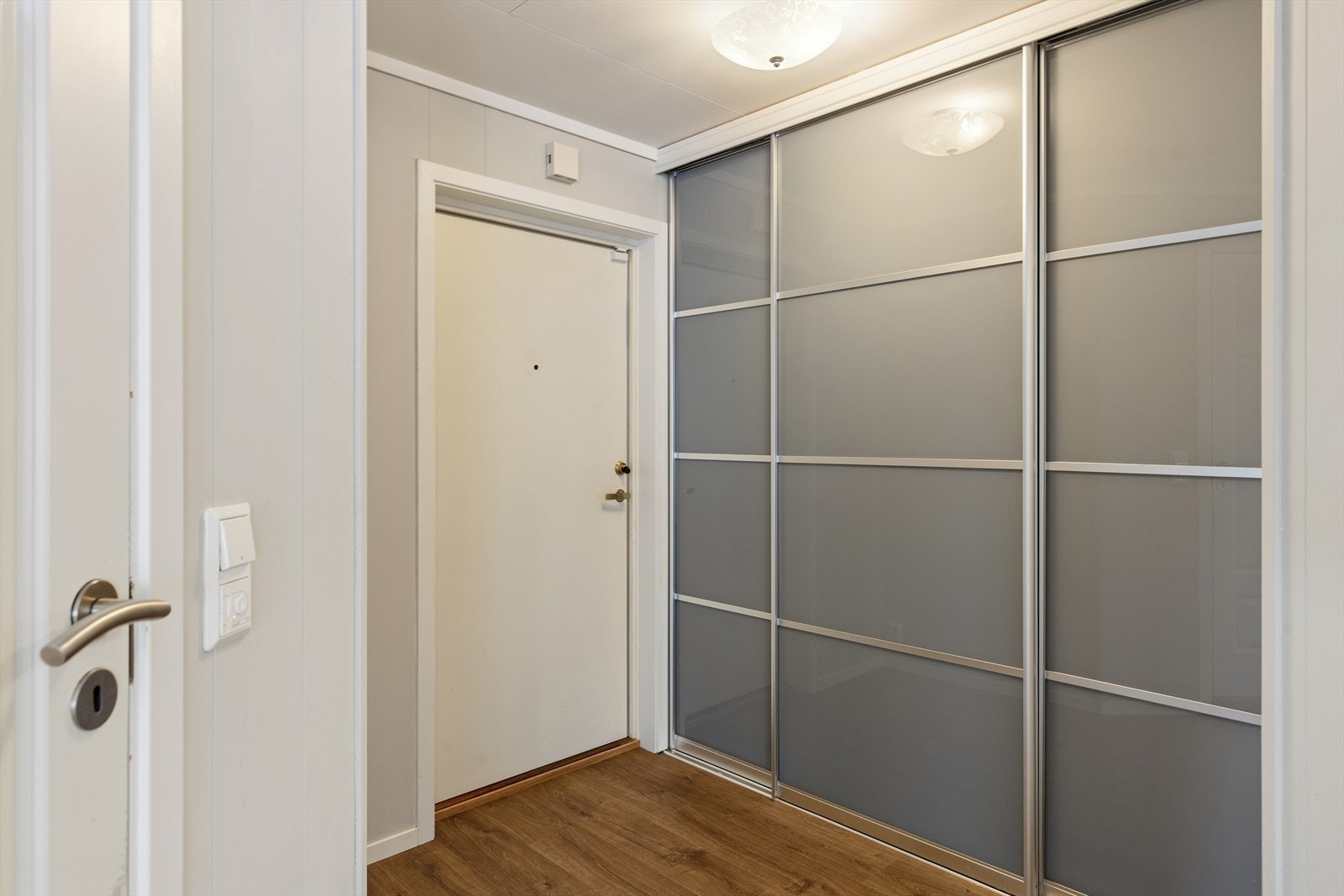 Når du trer inn i leiligheten møtes du av en lys entré. Her finner du en praktisk skyvedørsgarderobe med god plass til yttertøy, sko og oppbevaring. Galleribilde