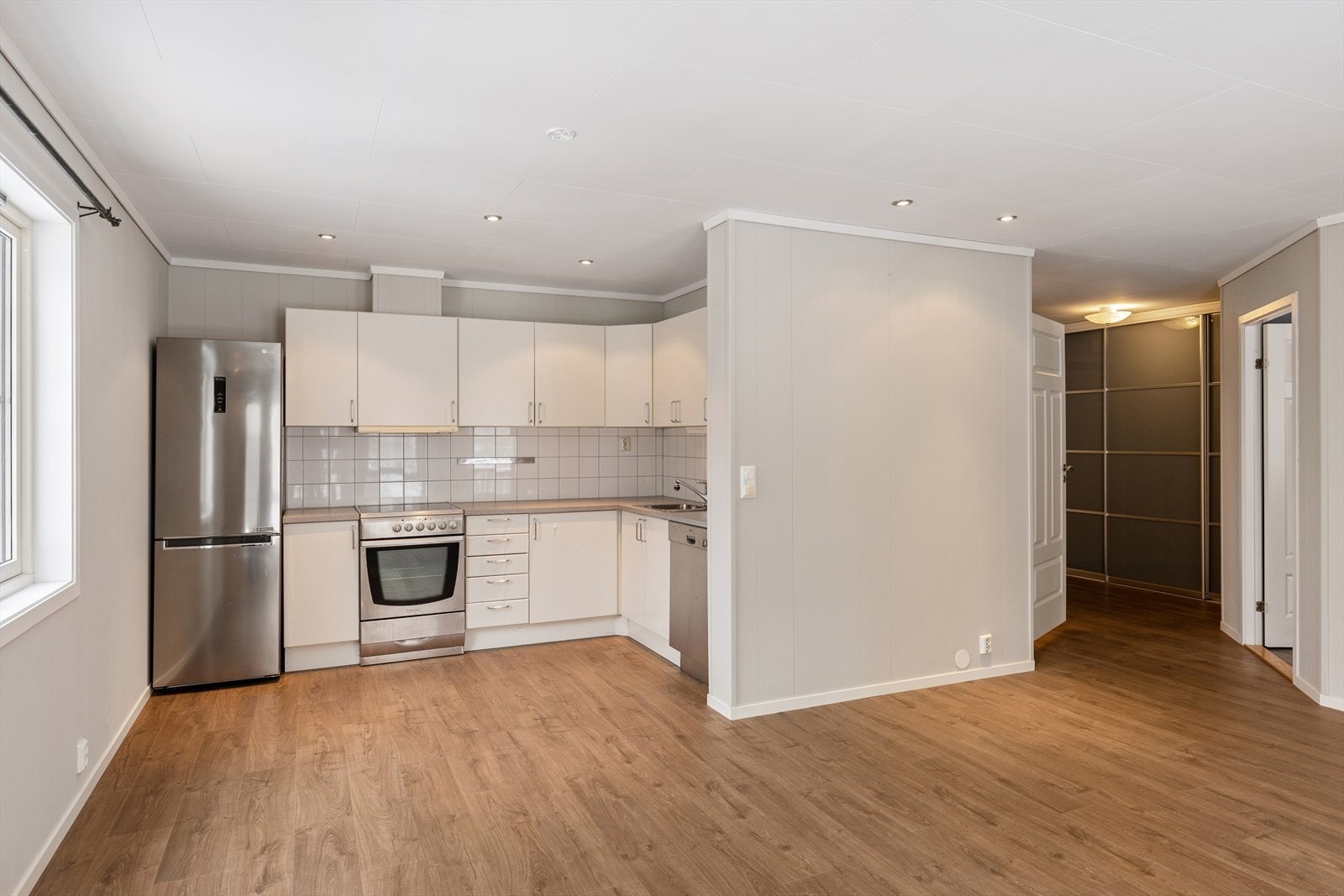 Den åpne stue- og kjøkkenløsningen er leilighetens hjerte. Her får du en sosial og luftig sone med naturlige inndelinger for både sofagruppe og spisebord. Galleribilde