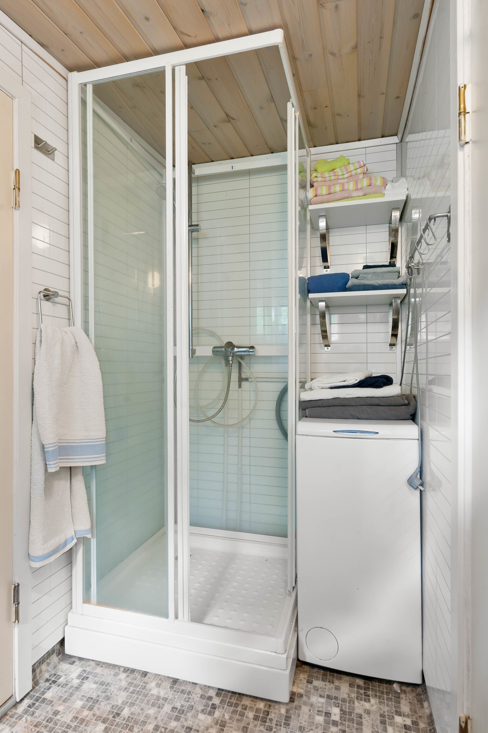 Innredningen består av en mørk benkeplate i laminat med frittstående servant og speil med skjult lagringsplass. Badet er ellers innredet med dusjkabinett og opplegg til vaskemaskin. Galleribilde