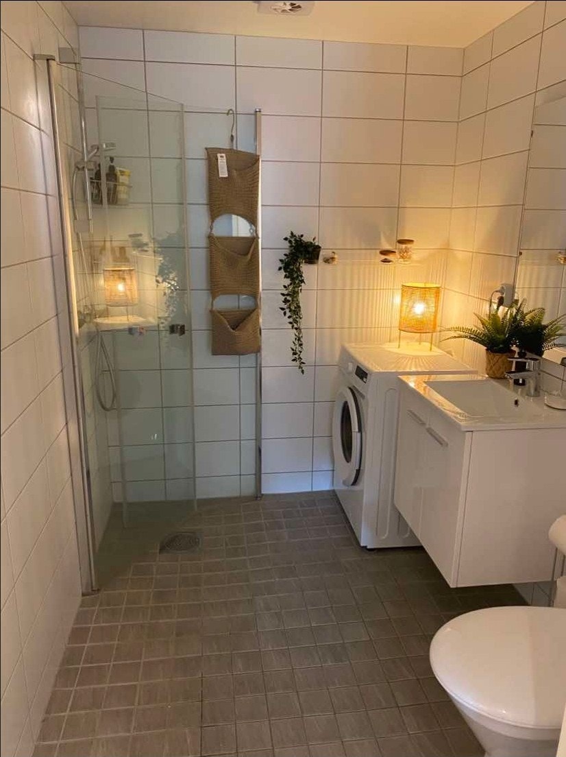 Romslig flislagt bad med innfellbare dusj dører og opplegg for å ta med egen vask/tørk. Bilde fra arkiv. Galleribilde