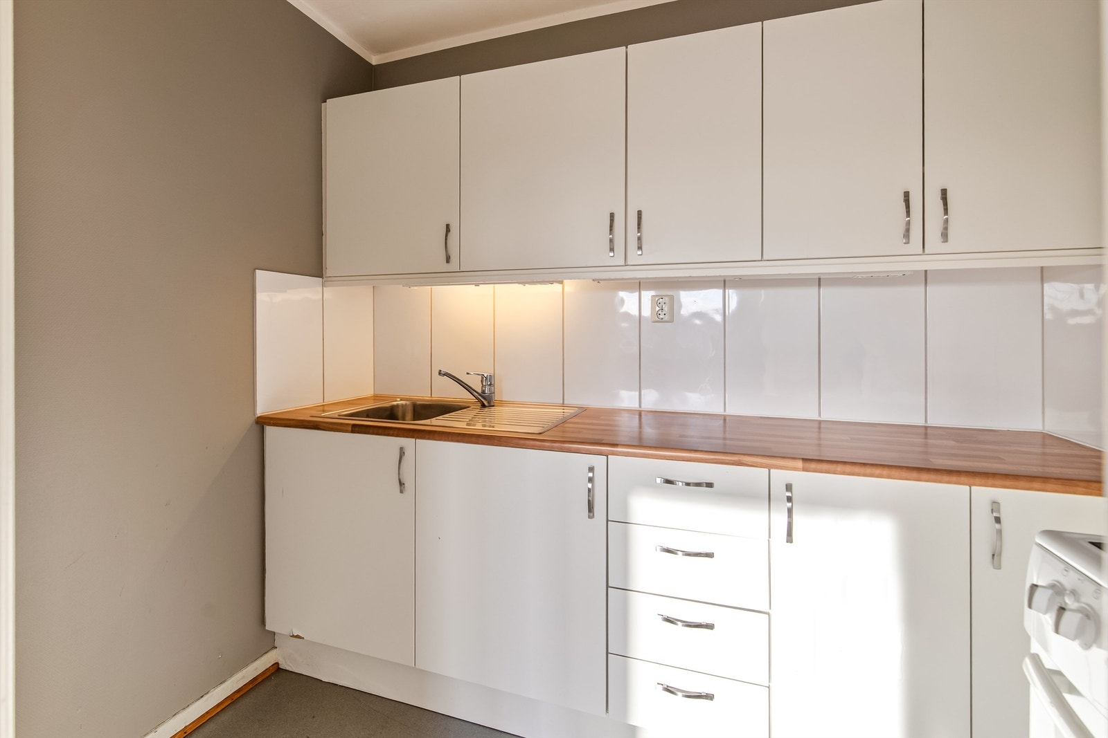 Godt med lagringsplass på kjøkkenet og flis mellom benkeplate og overskap Galleribilde