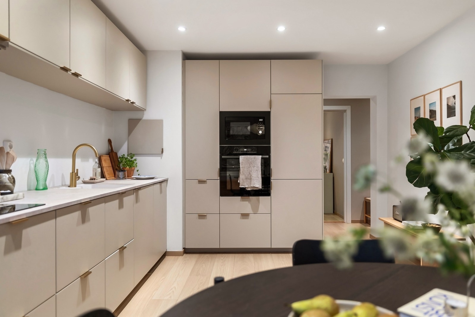 Integrerte hvitevarer som kjøleskap med frysedel, oppvaskmaskin, stekeovn, mikrobølgeovn og induksjonskoketopp med kullfilterventilator over Galleribilde