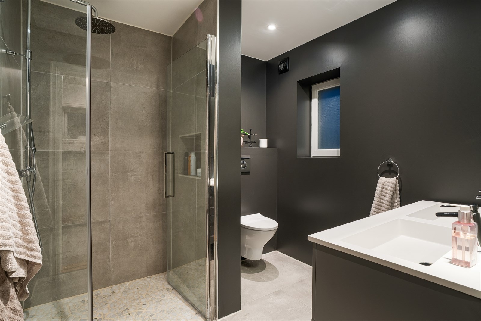 Lekkert bad med dusjnisje, vegghengt toalett og baderomsinnredning med dobbel servant Galleribilde