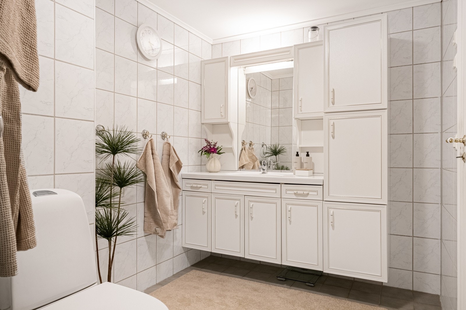 Det 5,5 kvm store badet har flislagte overflater og behagelig gulvvarme. Badet er utstyrt med en romslig baderomsinnredning med god lagringsplass, toalett og dusjkabinett. Galleribilde