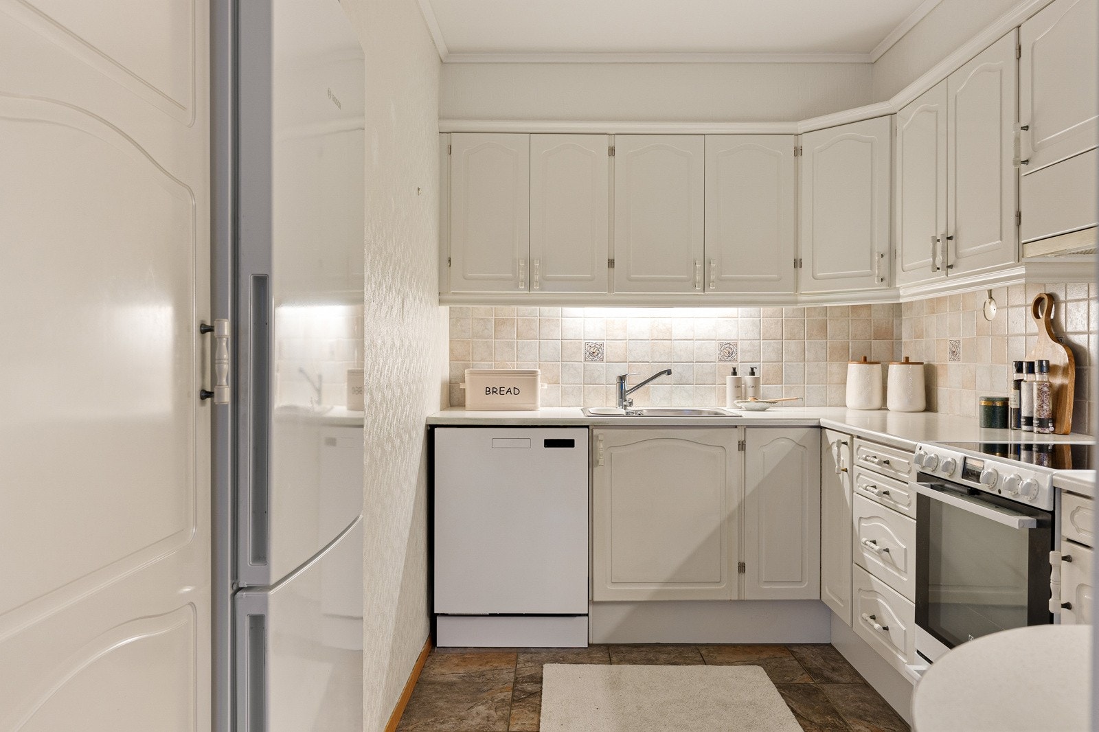 Kjøkkenet ligger tilbaketrukket i rommet. Kjøkkenet har godt med skap- og benkeplass. Galleribilde