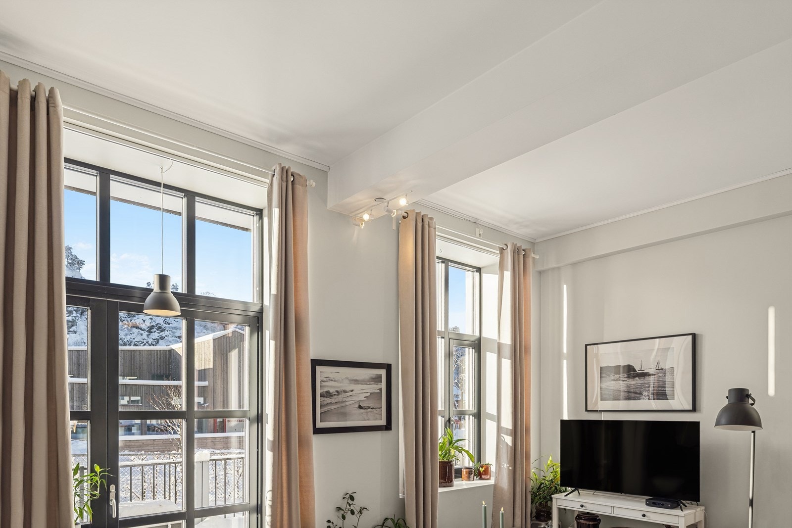 Høye, store vinduer sørger for godt med naturlig lys og den gode takhøyden gjør at det blir en fin romfølelse og en meget behagelig leilighet å være i. Galleribilde