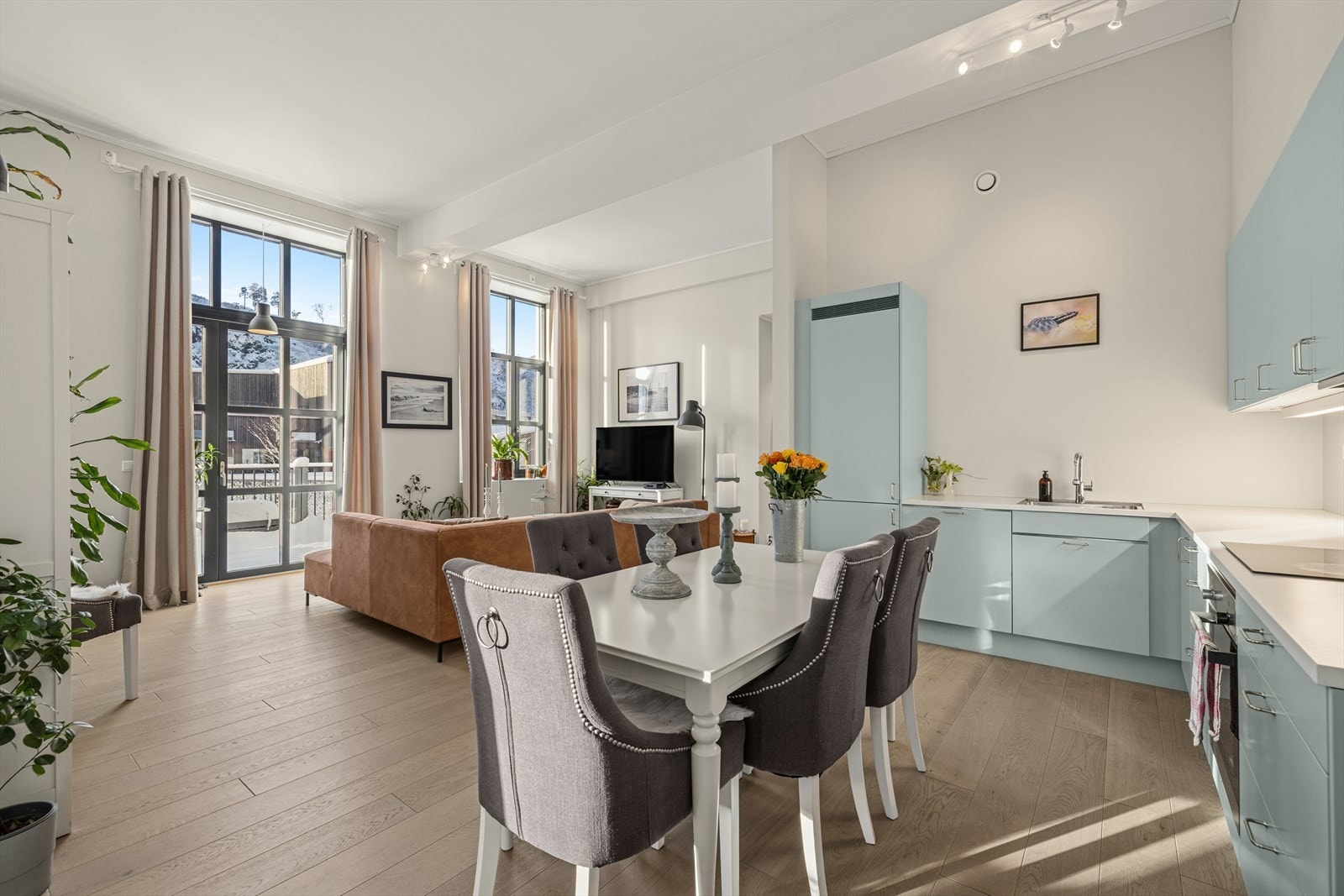 Stuen har en åpen og sosial løsning mot kjøkkenet. Galleribilde