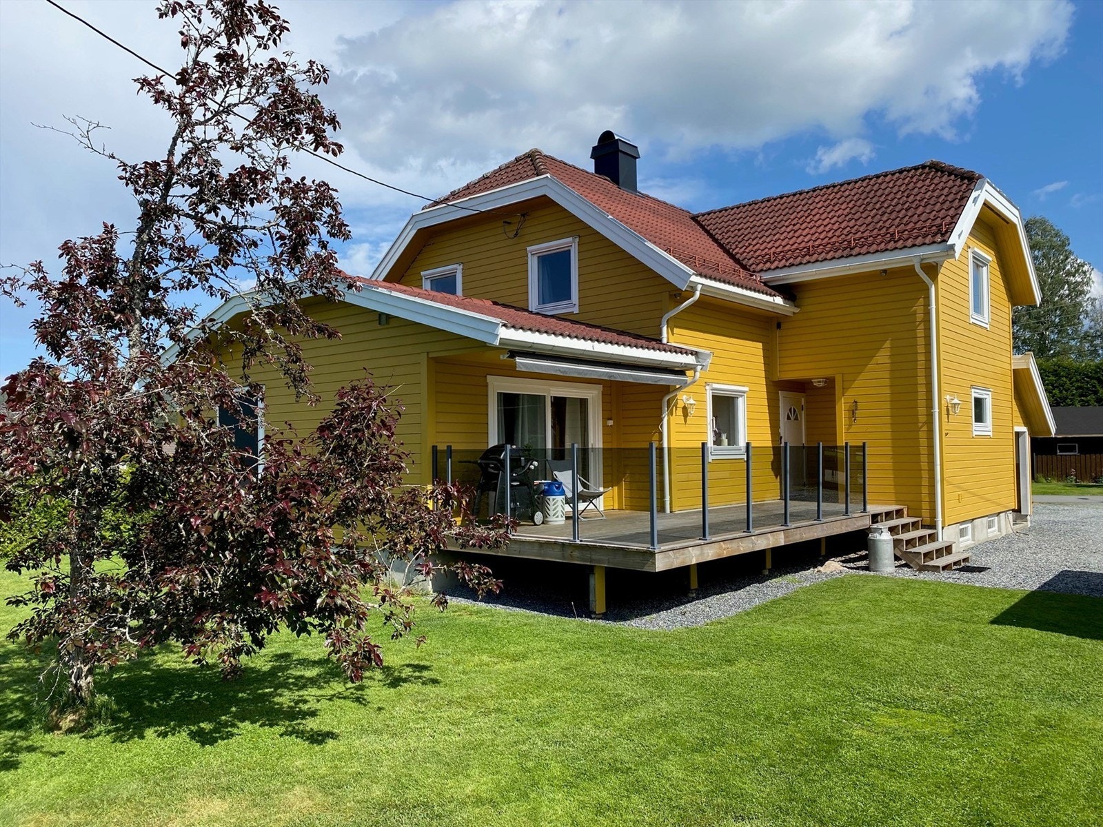 Rekkverk av stålprofiler med glassfelter. Skyvedør mellom terrassen og stuen. Galleribilde