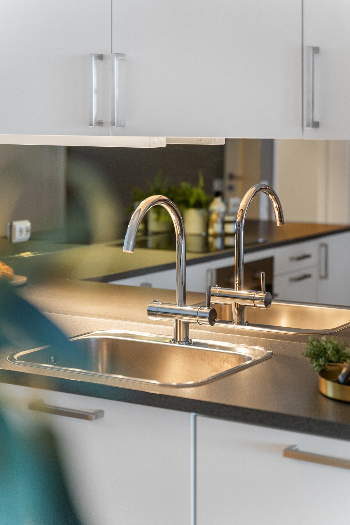 Kjøkkenet er utstyrt med dobbel vask og moderne blandebatteri - praktisk for både matlaging og oppvask. Stilrent uttrykk og funksjonell utforming. Galleribilde