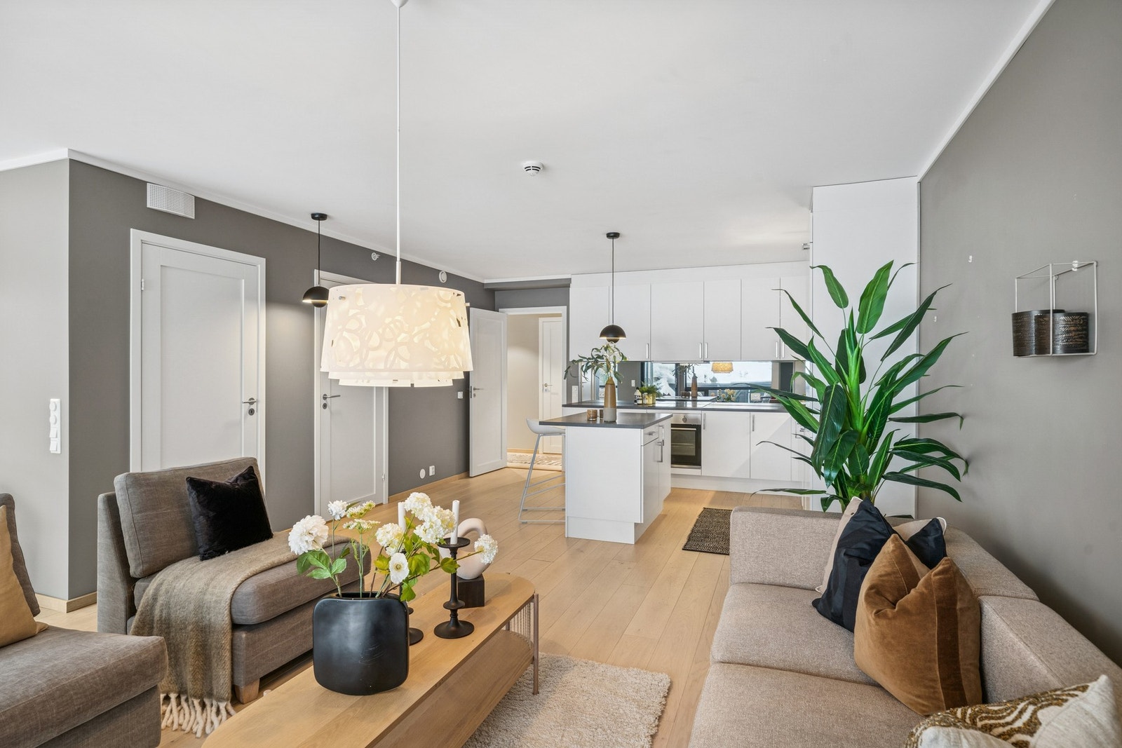 Den åpne løsningen mellom stue og kjøkken gir boligen en luftig atmosfære. Kjøkkenet ligger naturlig plassert med utsikt til både spiseplass og terrasse Galleribilde