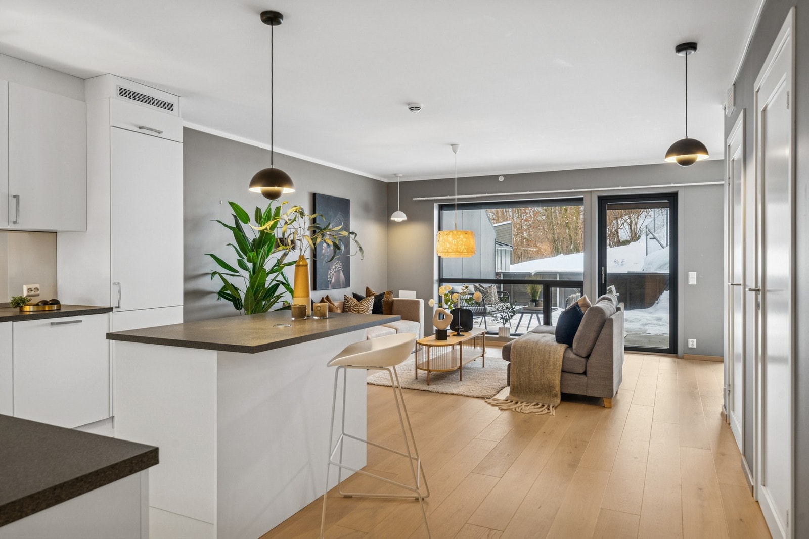 Det er sømløs tilgang til terrassen fra stuen. Den lune atmosfæren inne videreføres ute, og gir boligen en helhetlig og gjennomført stil. Galleribilde