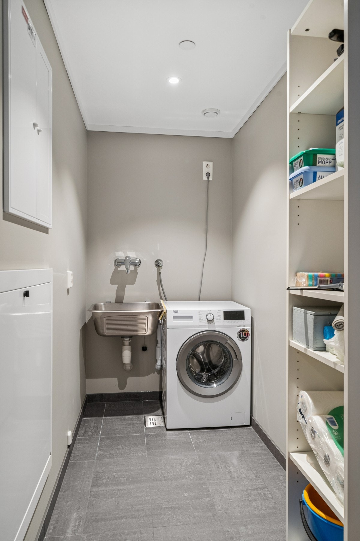 Separat vaskerom med vaskemaskin, skyllekum og god oppbevaringsplass. Perfekt for klesvask og organisering av husholdningsartikler. Galleribilde