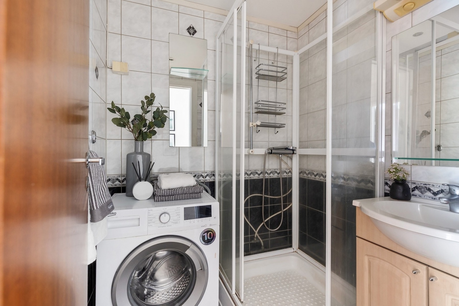 Leiligheten har et lyst bad med flislagte gulv og vegger. Det er opplegg for vaskemaskin. Galleribilde