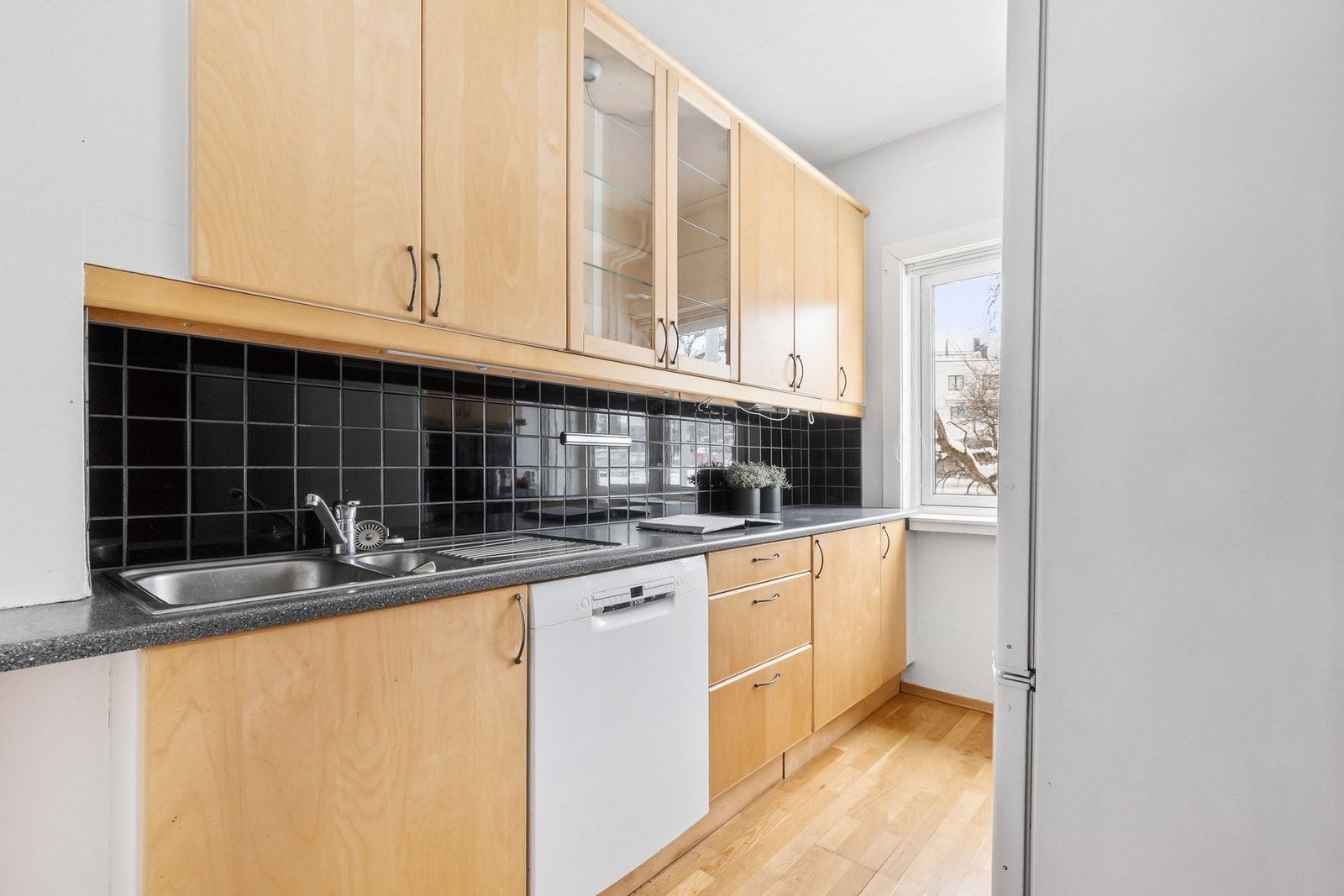 Separat kjøkken med slette skapfronter og laminerte benkeplater. Galleribilde