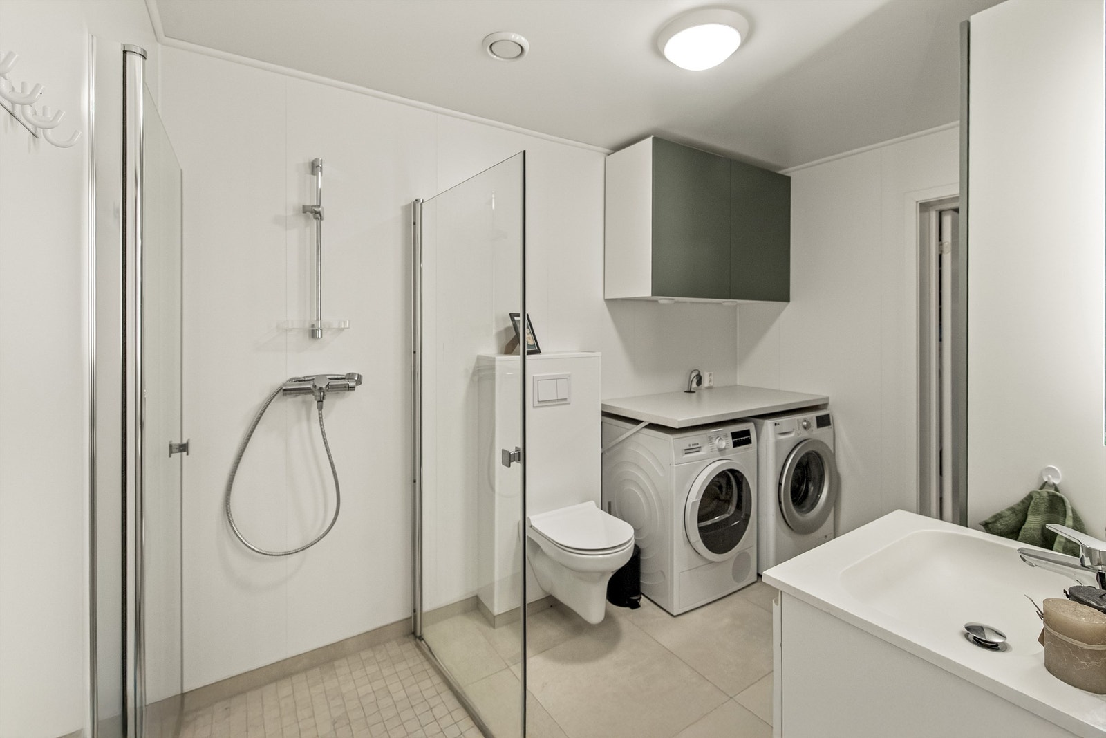 Kombinert vaskerom og bad med adkomst til romslig bod Galleribilde