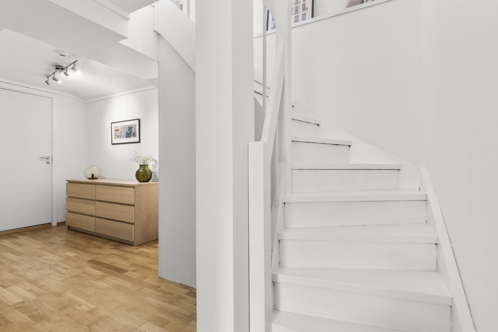 Lyst og romslig trapperom i underetasjen med plass til garderobe/ oppbevaring Galleribilde