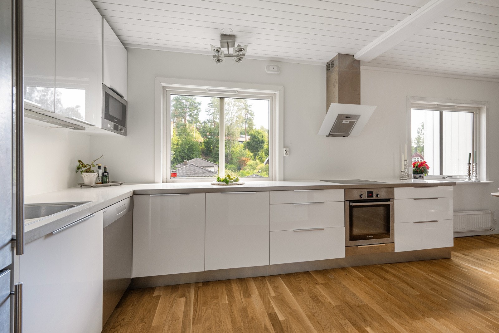 Kjøkkenet ligger i en egen sone og har en stilren innredning med slette fronter og benkeplate av laminat Galleribilde