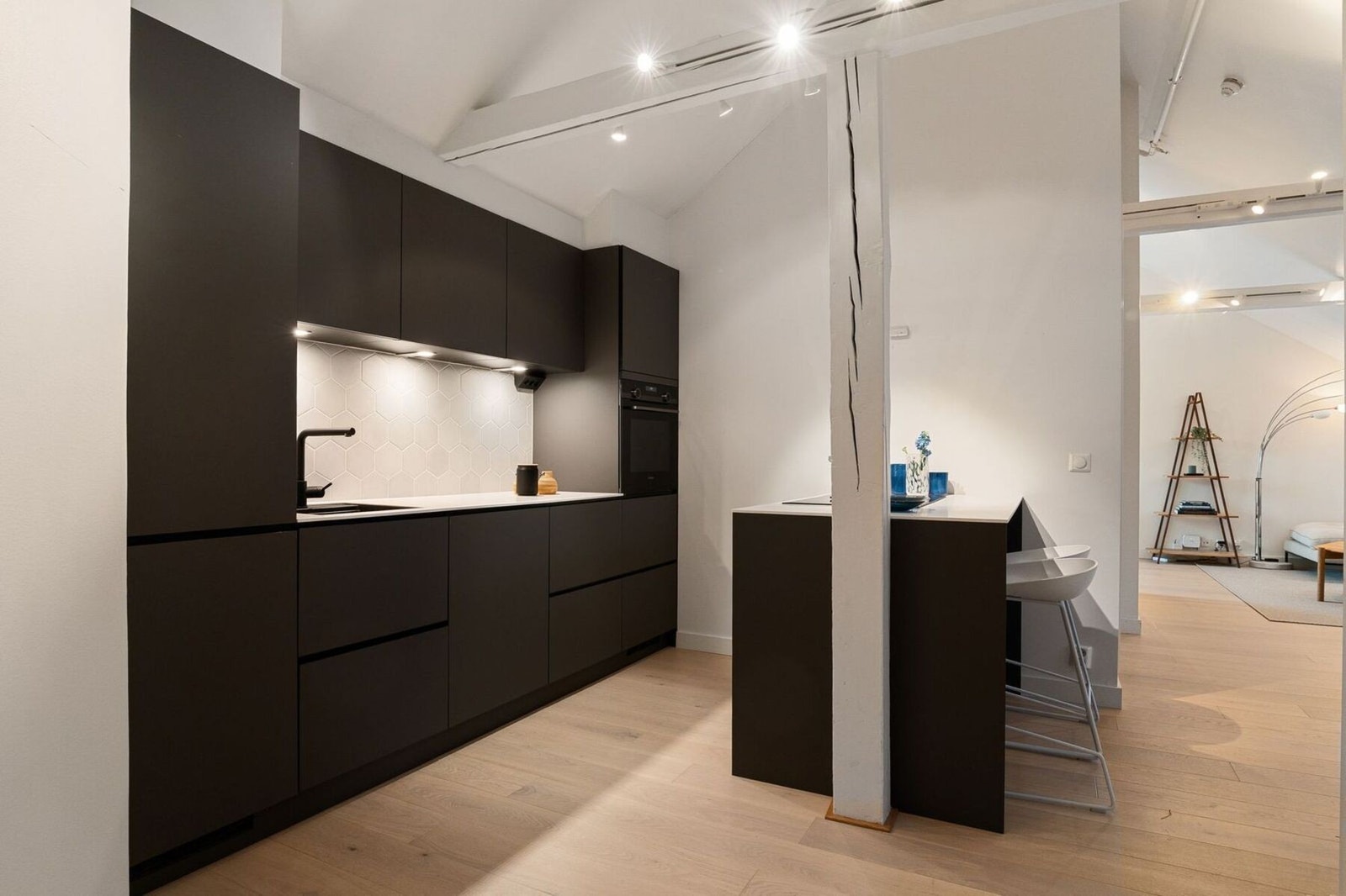 Kjøkkeninnredning med slette fronter i grå utførelse og benkeplater av stenkompositt. Galleribilde