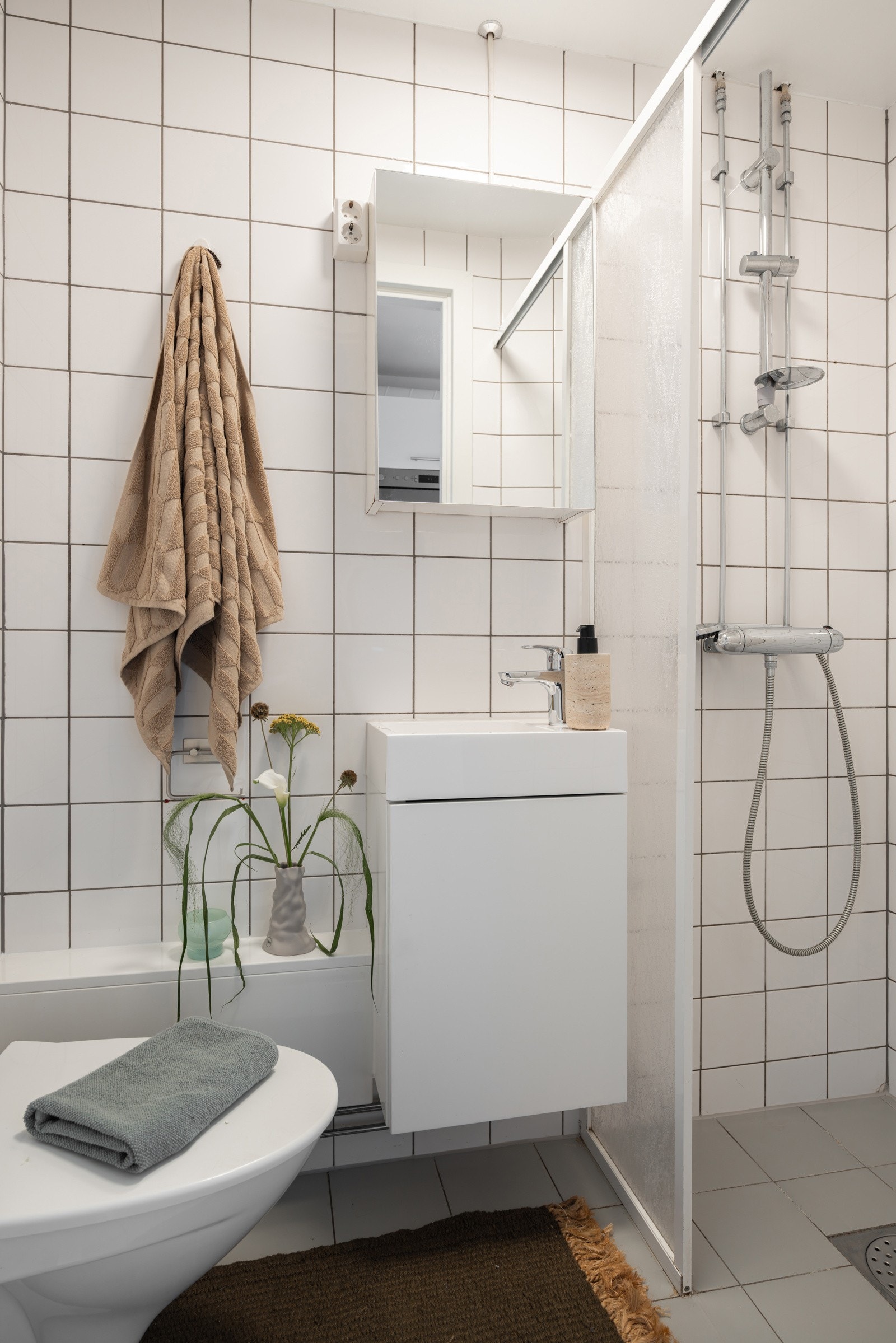 Baderommet er utstyrt med lyst servantskap med speilskap over, dusjnisje med delevegg og vegghengt toalett. Galleribilde