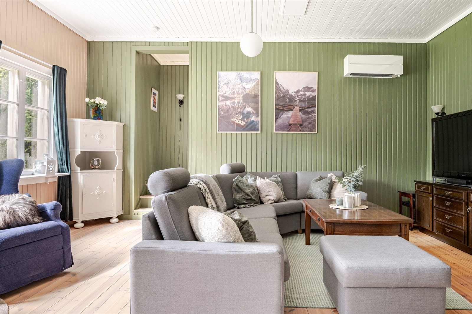 Stuen har en god atmosfære med lyse originale tregulv og panel på veggene som er malt i nydelig farger. Galleribilde