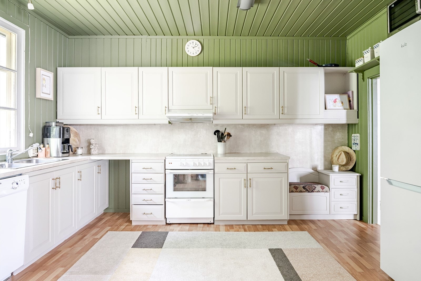 Innredningen har lyse profilerte fronter som ble malt i 2025 og laminert benkeplate med nedfelt oppvaskkum. Galleribilde