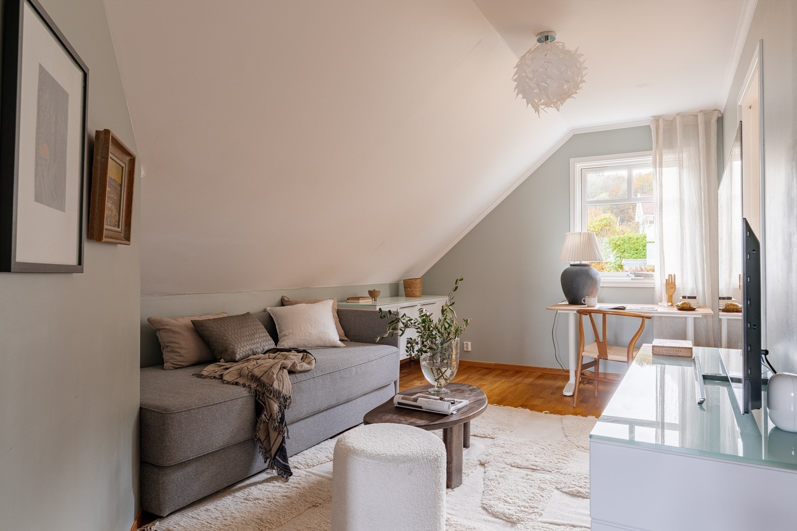 Hyggelig loftstue med parkett på gulv og malte overflater på vegger og himling. Galleribilde