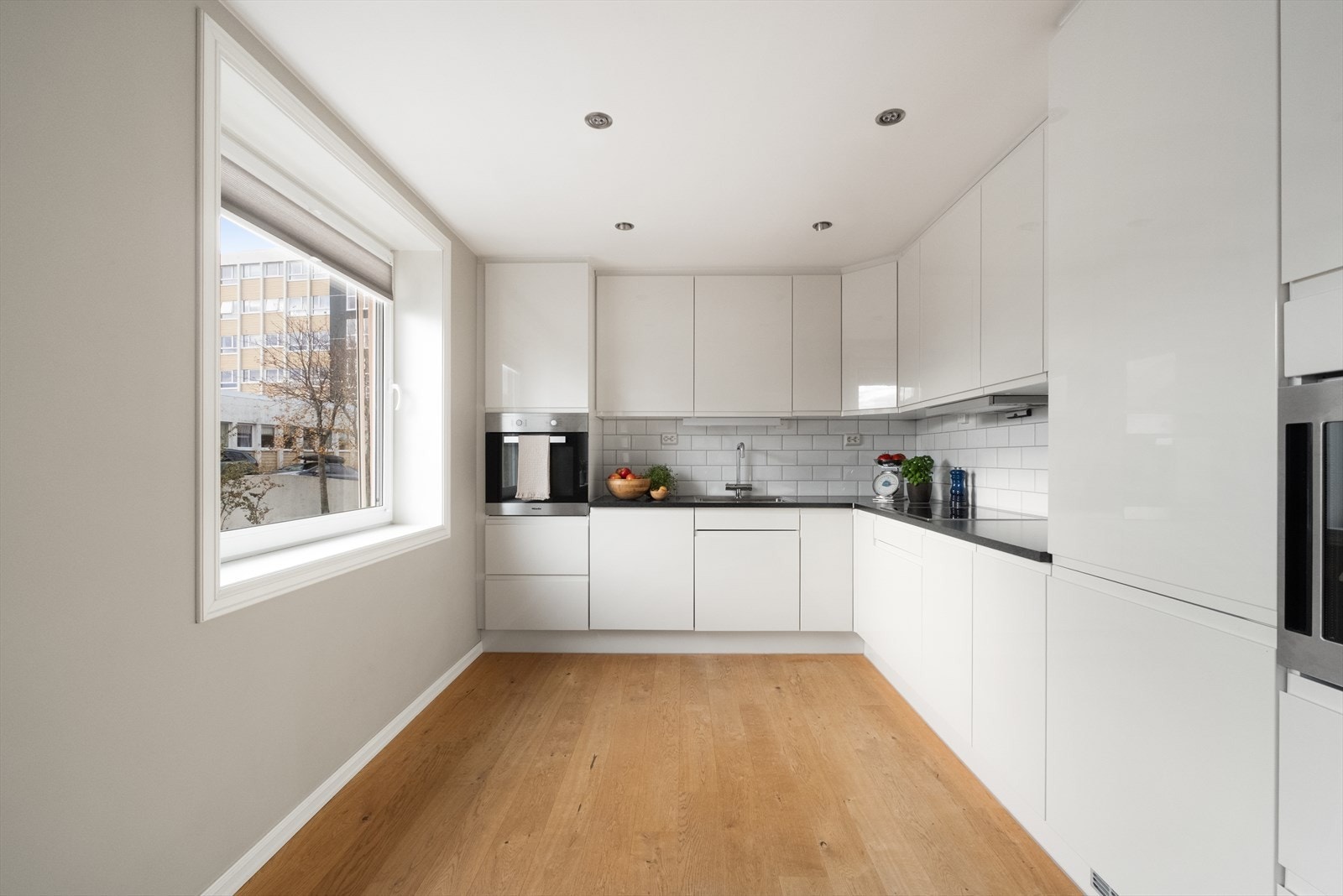 Store vindusflater gir naturlig lys til det åpne kjøkkenområdet. Galleribilde